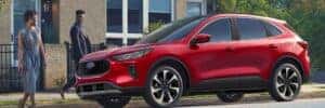 couple walking towards red 2025 ford escape