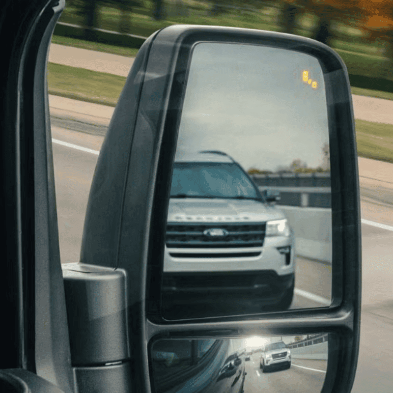 Side view mirror on a Ford vehicle showing the Blind Spot Assist alert