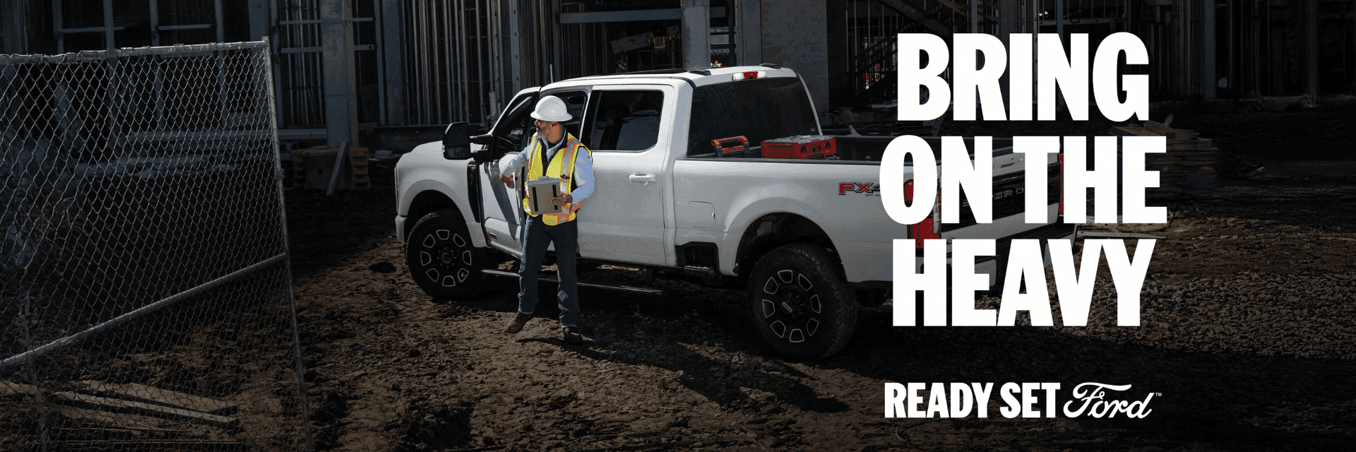 A manager stands outside their 2026 Ford Super Duty® truck at a build site