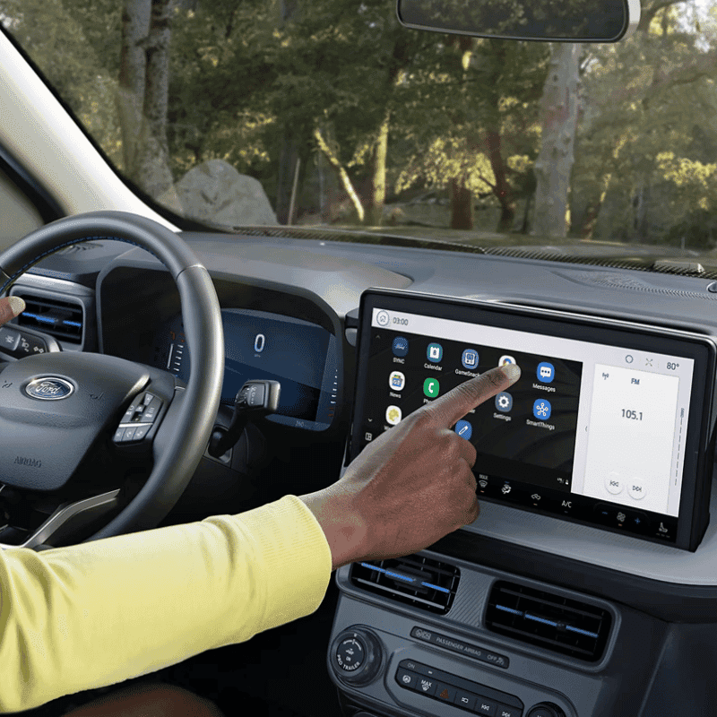 A driver using the touchscreen on a parked 2025 Ford Maverick® pickup