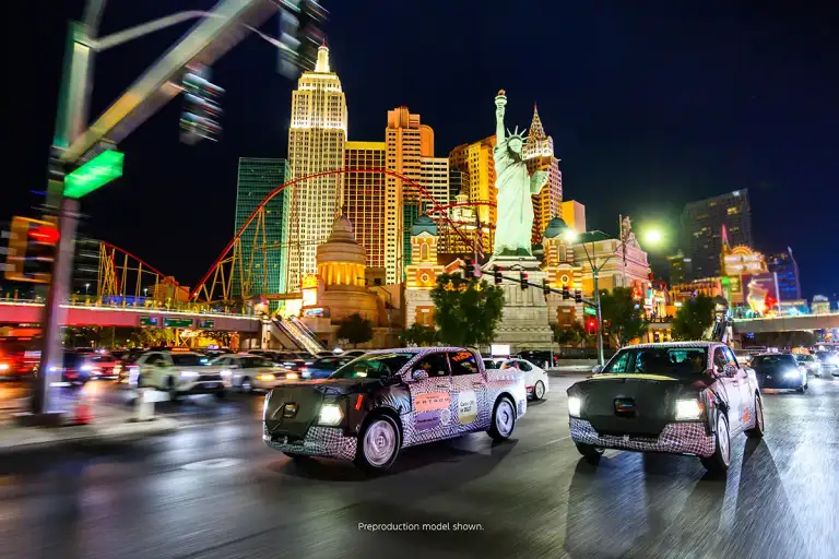 Two camouflaged Ford Fathom prototypes driving on the Las Vegas Strip at night