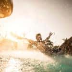 man splahsing into pool from slide at waterpark