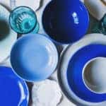 set of dishware in blue tones. Ceramic plates and water glasses top view
