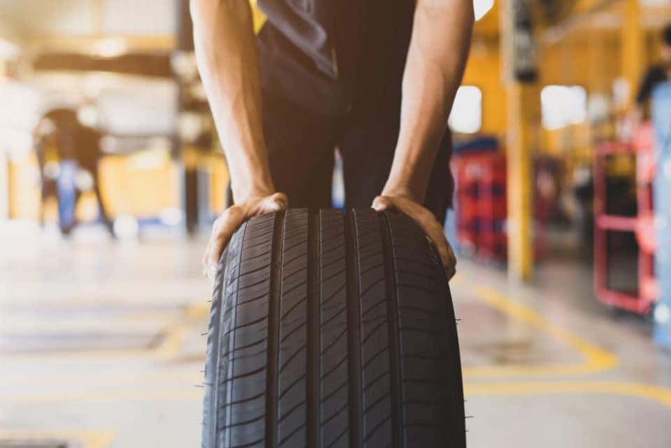 mechanic rolling out tire