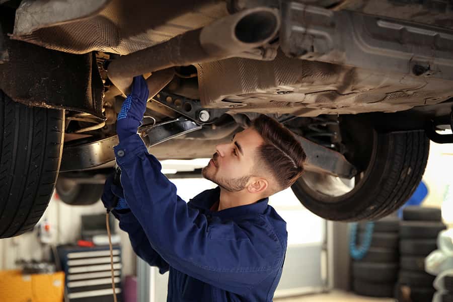service technician working underneath a vehicle