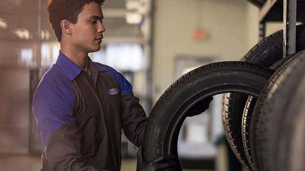 a view of a ford service member taking care of tires