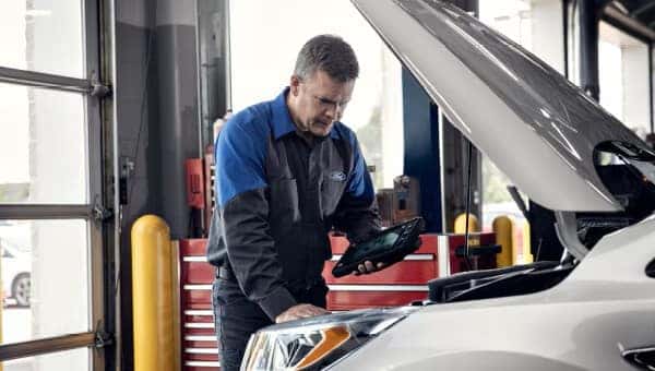 a ford service member performing a service inspection to a ford vehicle