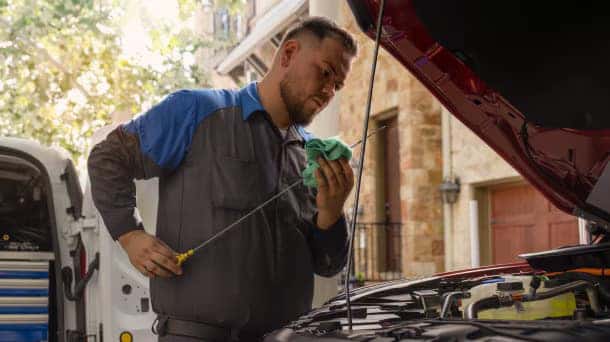 a ford service member performing an oil change on a ford vehicle