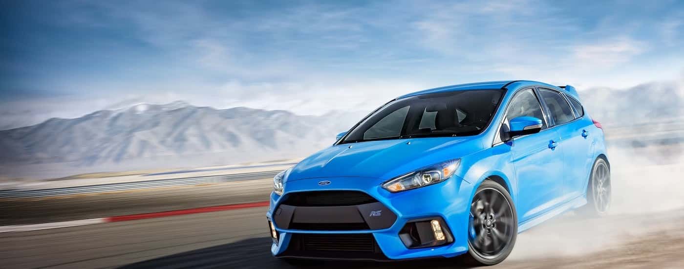 A blue 2017 Ford Focus Hatchback is racing around a track.