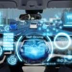 Inside of a vehicle with blue symbols and words floating in the air representing autonomous driving