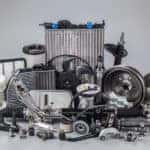 Silver car parts grouped together against a grey background