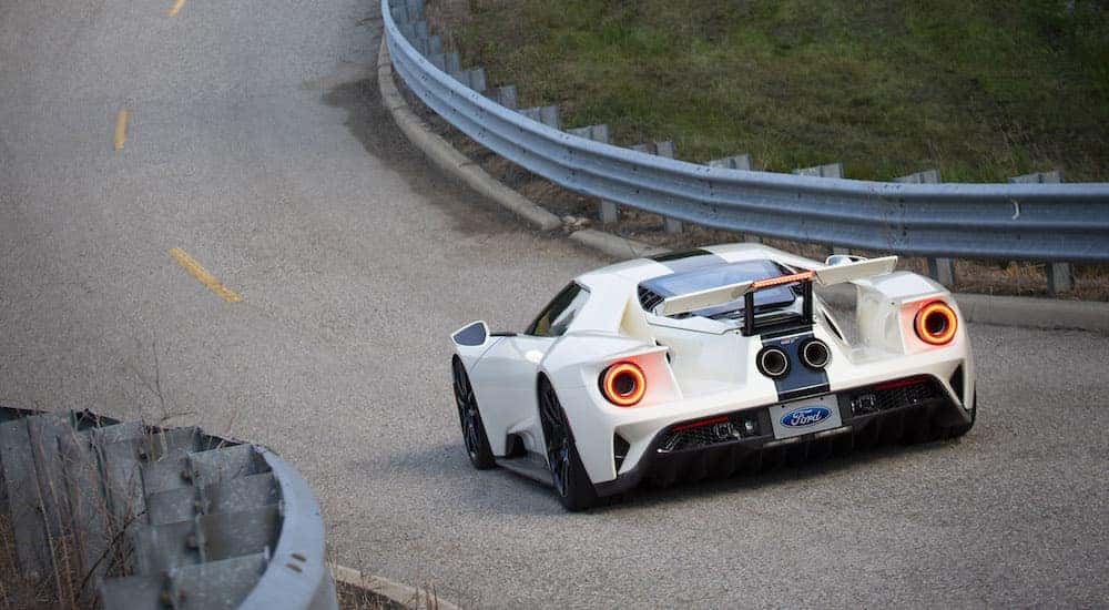A white 2022 Ford GT heritage edition is shown from the rear on a racetrack.