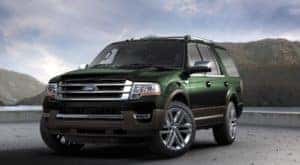 One of the most popular used SUVs for sale, a green 2016 Ford Expedition, is shown parked near mountains.