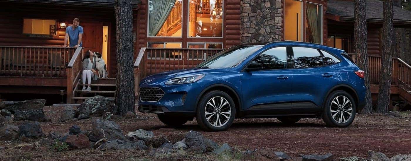 A blue 2022 Ford Escape is shown parked near a cabin.