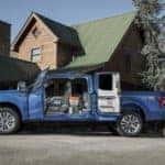 A blue 2019 Ford F-150 is parked in front of a house with the cab doors open near Albany, NY.