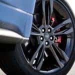 Close-up shot of a 2019 Ford Edge ST wheel, including a black alloy rim and performance tire, outfitted with a high-performance braking system