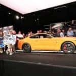 yellow 2020 Ford Mustang Shelby GT500 on a black stage at the Barrett-Jackson Auction surrounded by fans and families impacted by Juvenile Diabetes