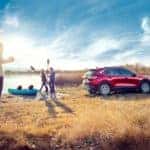 red 2020 Ford Escape parked next to a pond with three adults and a light blue kayak