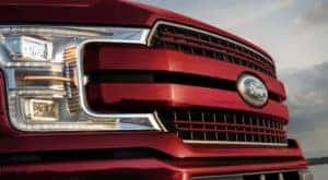 The grille of a red 2020 Ford F-150 is shown in a close up.
