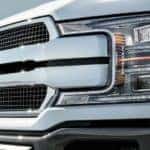 A close up of a white 2019 Ford F-150's grille is shown.