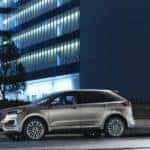 Silver 2020 Ford Edge parked on the street in front of a glass office building with blue lights in the windows