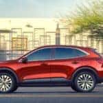 Red 2020 Ford Escape parked in front of a silver fence with a white building behind it