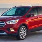 Red used Ford Escape parked on pavement in front of water with an island in the background