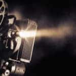 Film camera with reels on the side, lighting up a dark room
