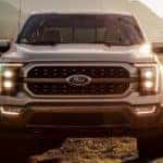 A white 2021 Ford F-150 like this one, shown from the front at sunset, is coming to a new car dealership near you.