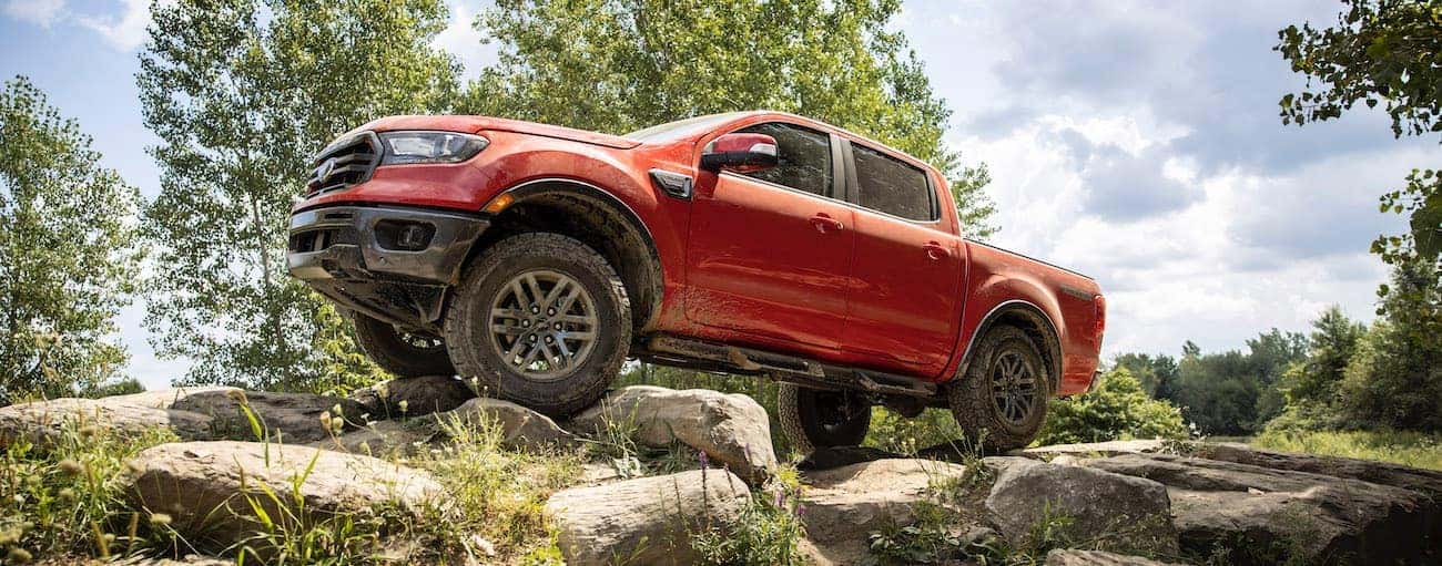 A red 2021 Ford Ranger is off-roading on a rocky trail.