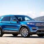 A blue 2020 Ford Explorer Hybrid is parked near the water.