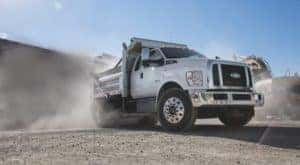 A white 2021 Ford F-650 is parked at a dusty gravel pit.