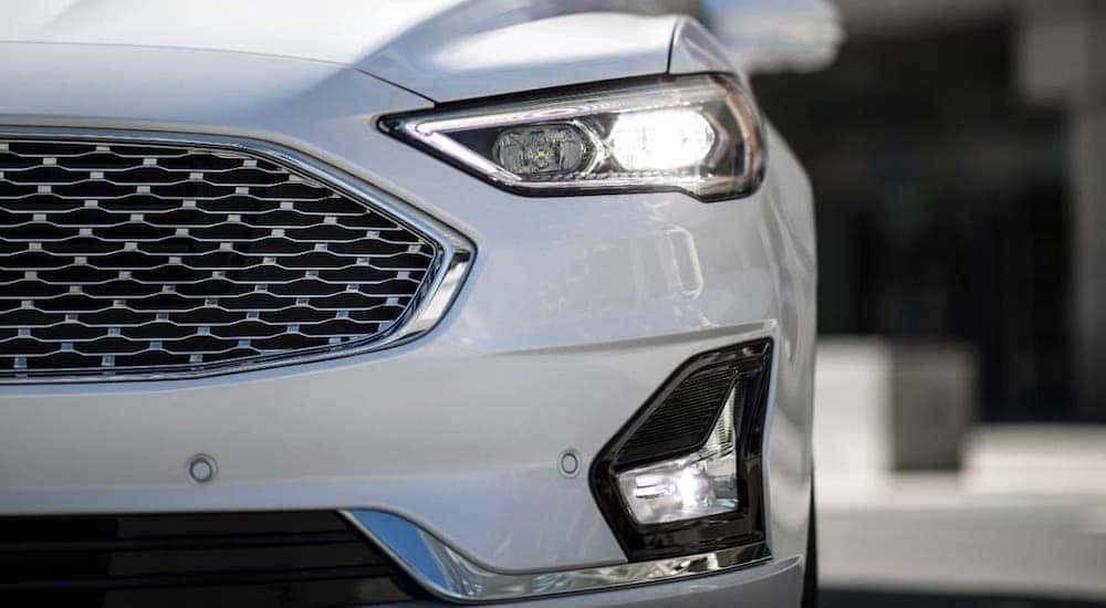 A closeup shows the grille of a white 2020 Ford Fusion at an Albany car dealer.