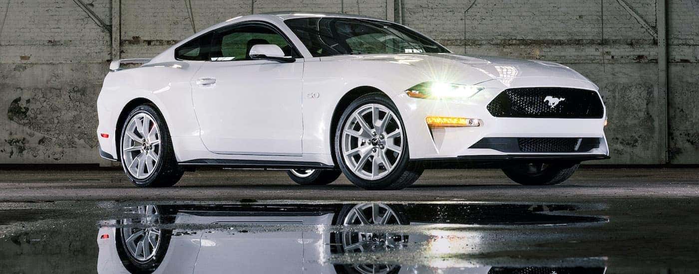 A white 2022 Ford Mustang Ice White Edition is shown in a warehouse.