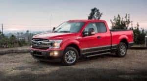 A red 2018 Ford F-150 Powerstroke diesel is parked on a dirt road.
