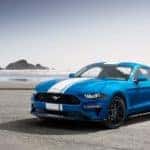 A blue 2020 Ford Mustang is parked on a beach.