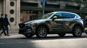A green 2020 Mazda CX-5 is parked on a city street after leaving a used Mazda dealership.
