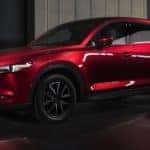 A red 2018 Mazda CX-5 is shown parked in a modern gallery.
