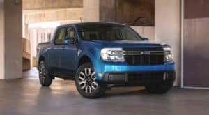 A blue 2022 Ford Maverick is parked inside of a NY Ford Maverick dealer.