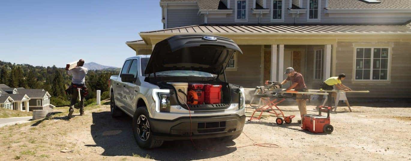 A silver 2022 Ford F-150 Lightning Pro is shown on a construction site.
