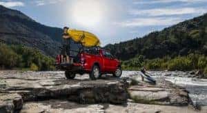 A man is shown securing a kayak to a red 2021 Ford Ranger XLT.
