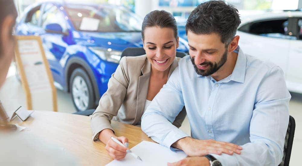 A couple is signing paperwork at a Ford Lease in Albany NY.