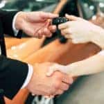 A salesman is shaking hands with a person after a returned Ford Lease in Albany NY.