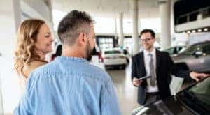 A couple is shown a vehicle at an Albany used vehicle dealership.