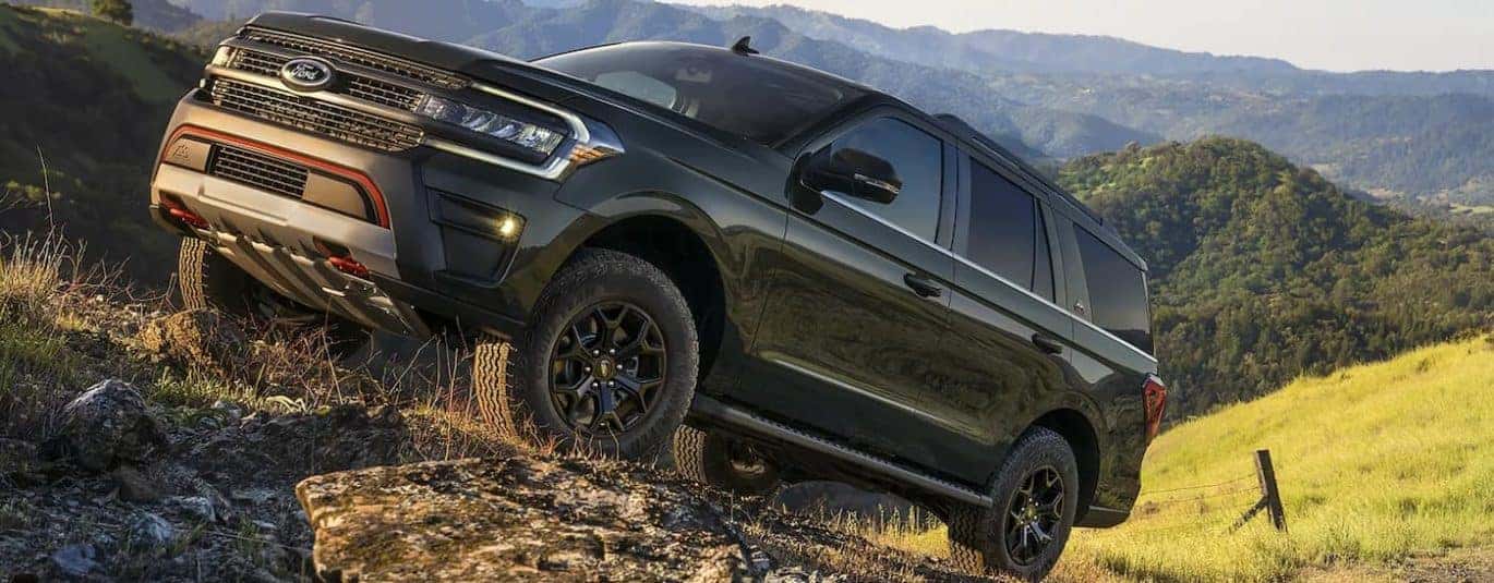 A green 2022 Ford Expedition Timberline is shown driving up a path after winning a 2022 Ford Expedition vs 2022 Toyota Sequoia comparison.