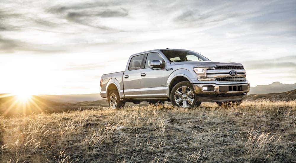 A silver 2018 Ford F-150 is shown parked in a field after leaving a certified pre-owned Ford F-150 dealer.