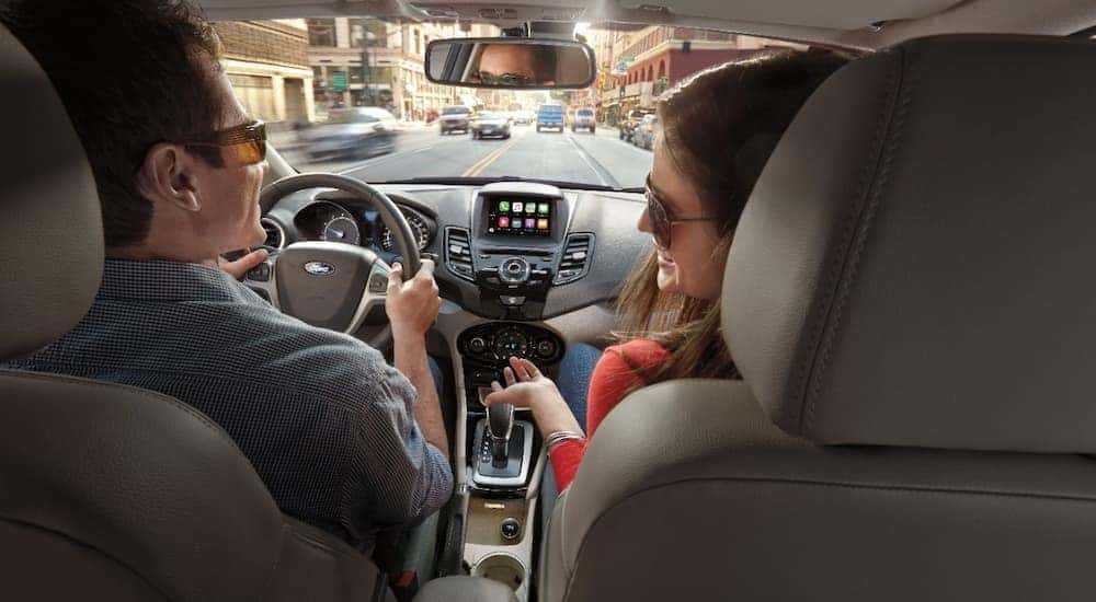 A couple is shown leaving a NY CPO Ford dealer in a 2017 Ford Fiesta.