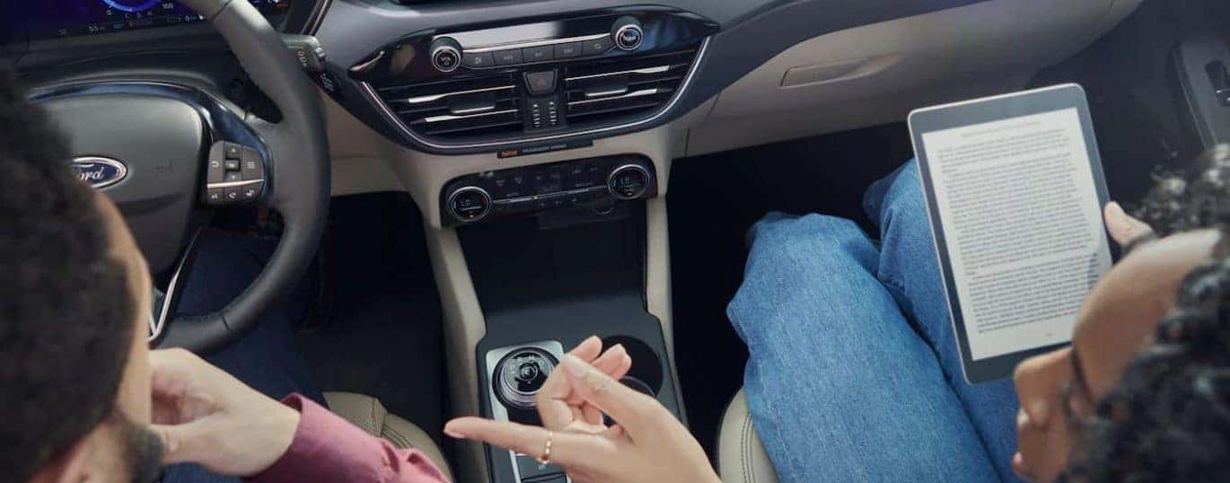 Two people are shown sitting in the front seats of a 2022 Ford Escape.