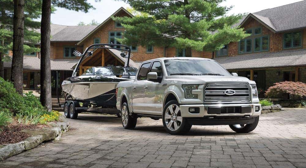 A white 2016 Ford F-150 Limited is shown with a boat in a driveway after the owner looked up ''Ford truck''.
