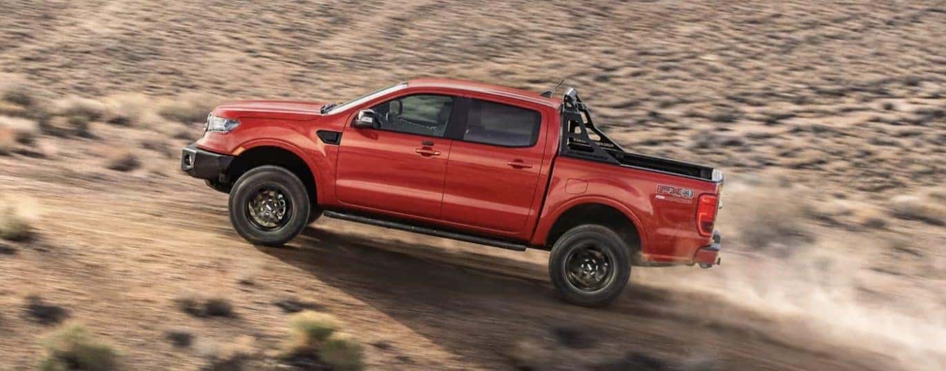A red 2022 Ford Ranger is shown from the side off-roading in the desert.